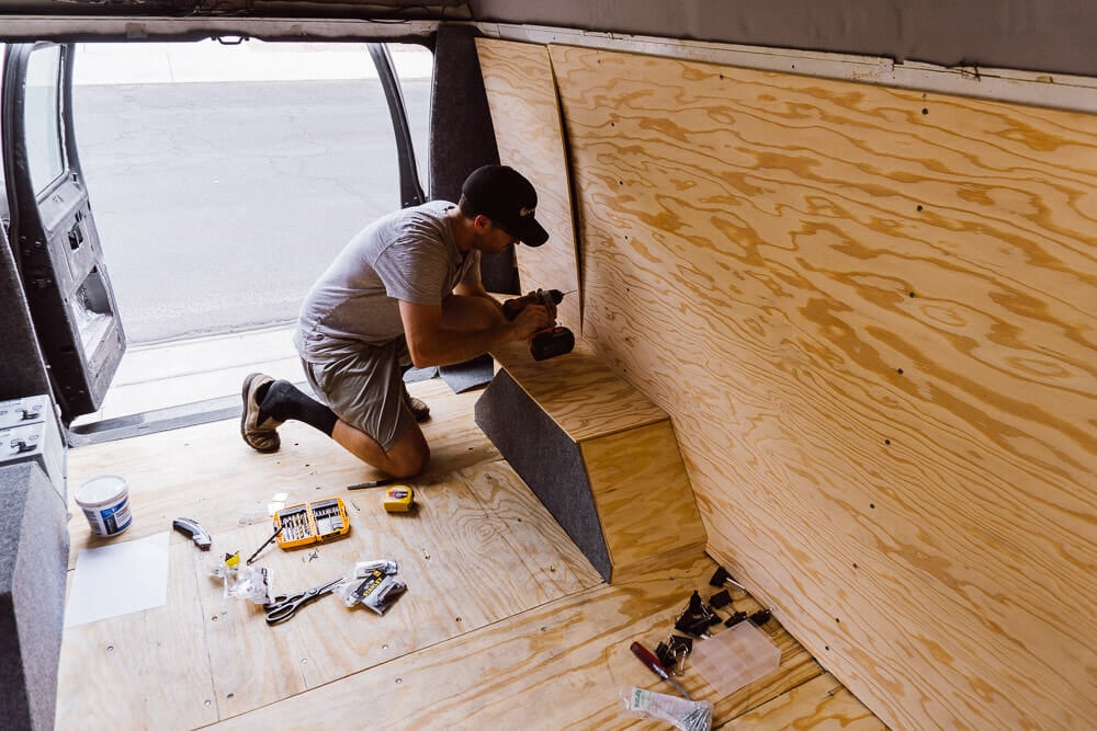 Attaching plywood walls to the van.