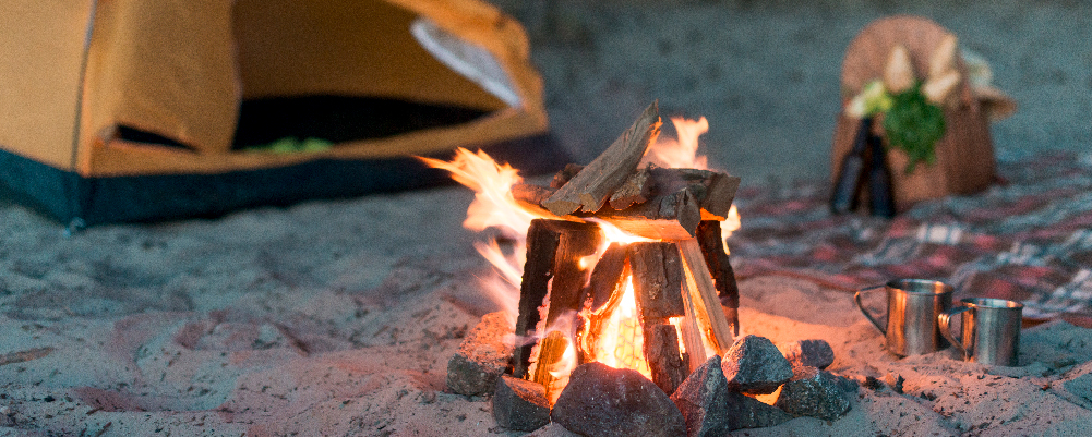 Campfire with tent in the background