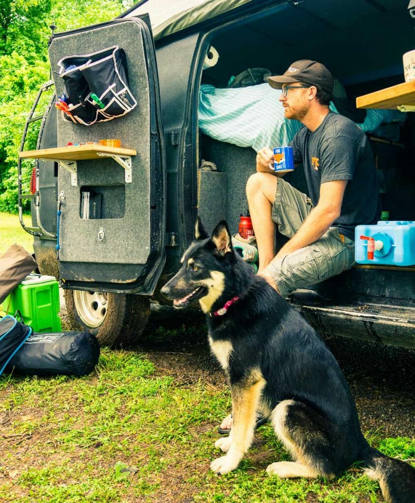 drinking coffee next to a dog in a van where we're living full time