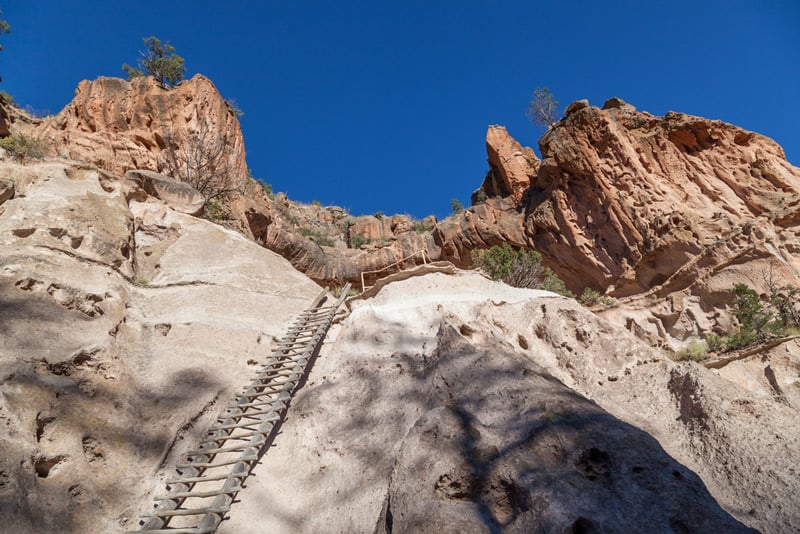 hiking up a ladder in bandelier national park in new mexico