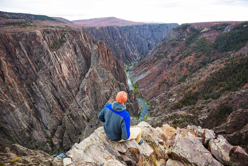 sitting on the edge of black canyon of the gunnison national park in colorado