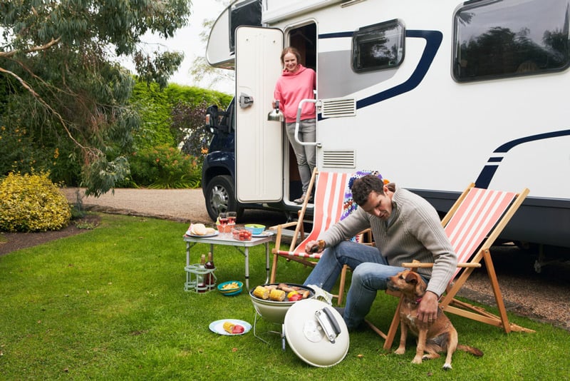 rv camping couple with a dog and vehicle insurance