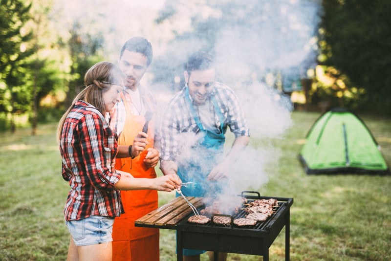 cooking on a portable grill at a camping site