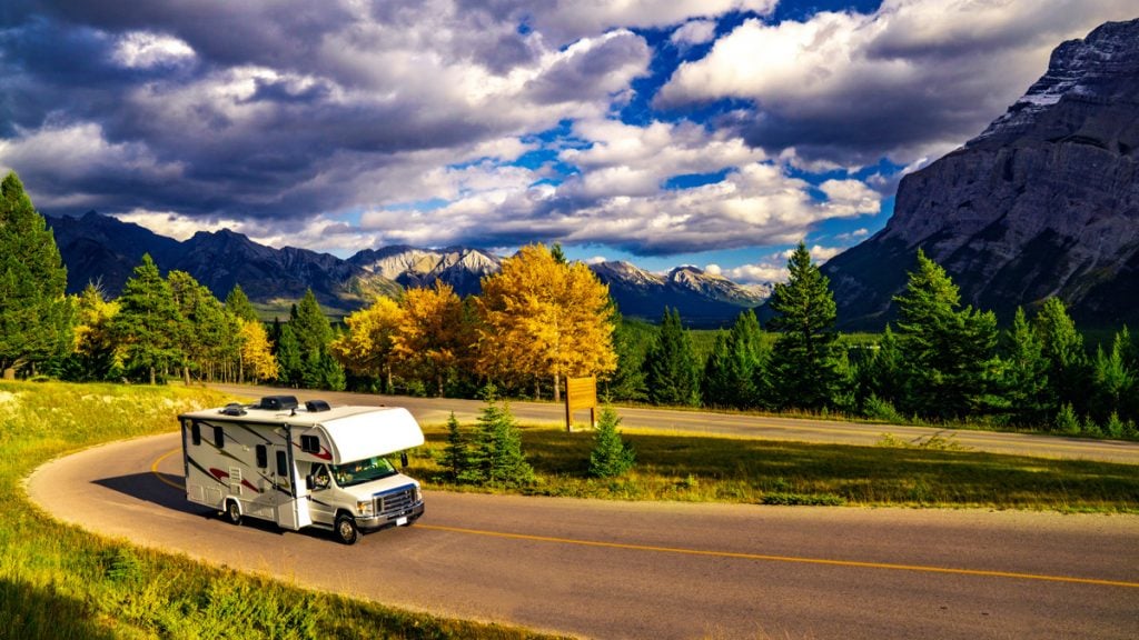 class c rv camper driving on a highway