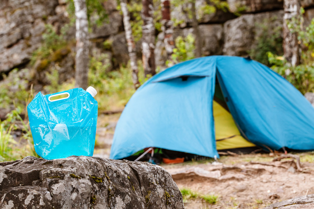 Collapsible camping water container at a campsite