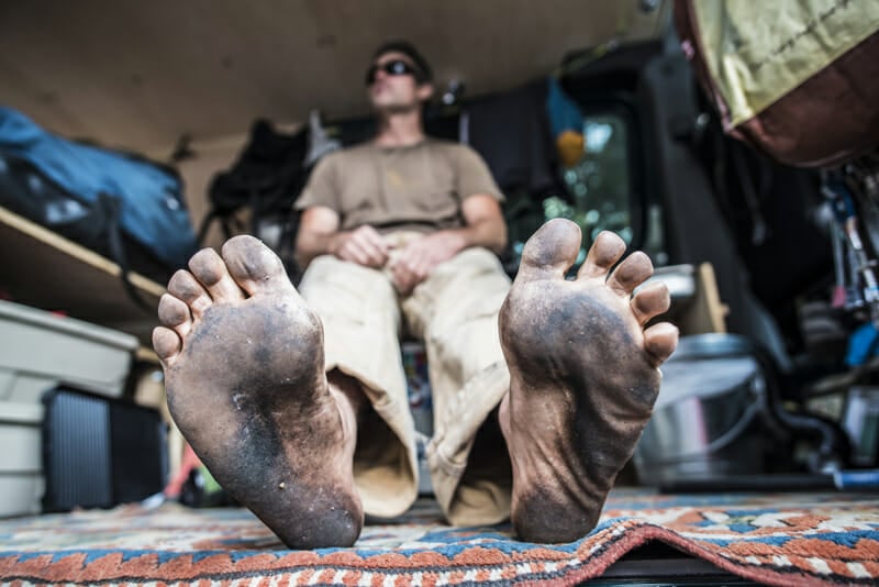 man with dirty feet demonstrating the need for a shower in a conversion van