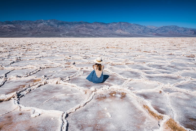 girl sitting in the salt flats among the crystals of badwater basin