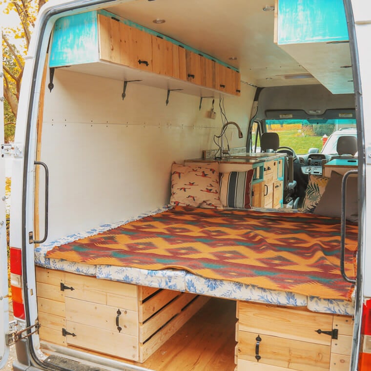 camper van conversion bed design that folds from a table to a bed