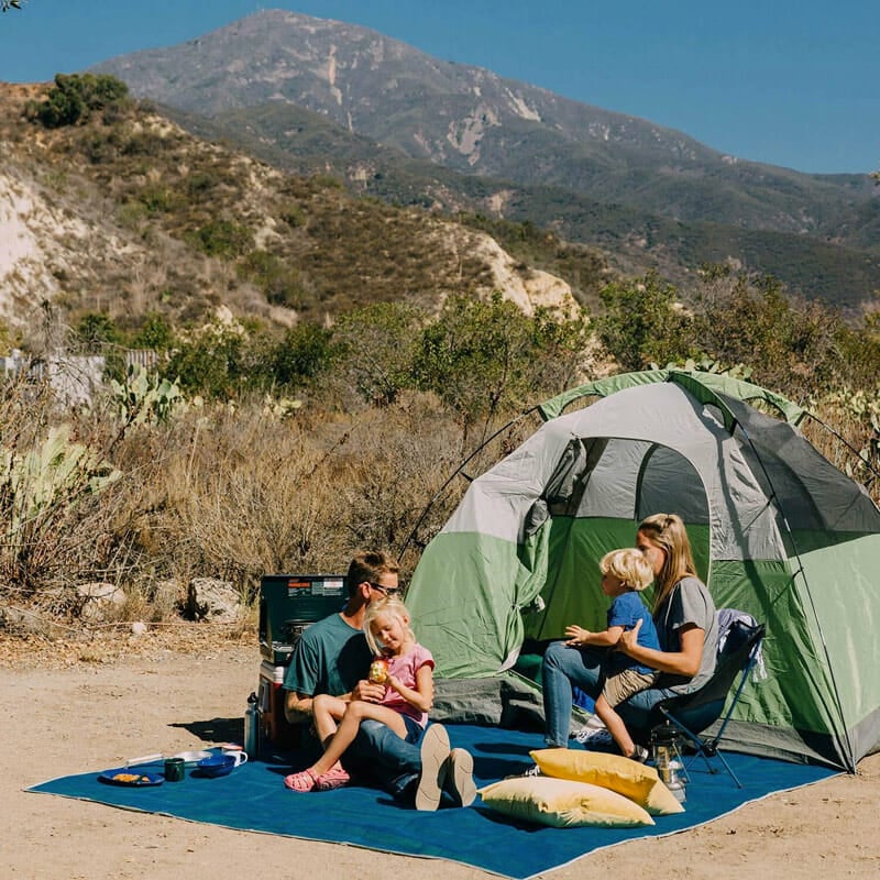 family tent camping with a sand free rug