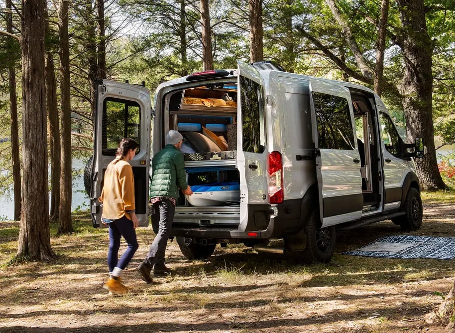 loading van life gear into the back of a ford transit trail