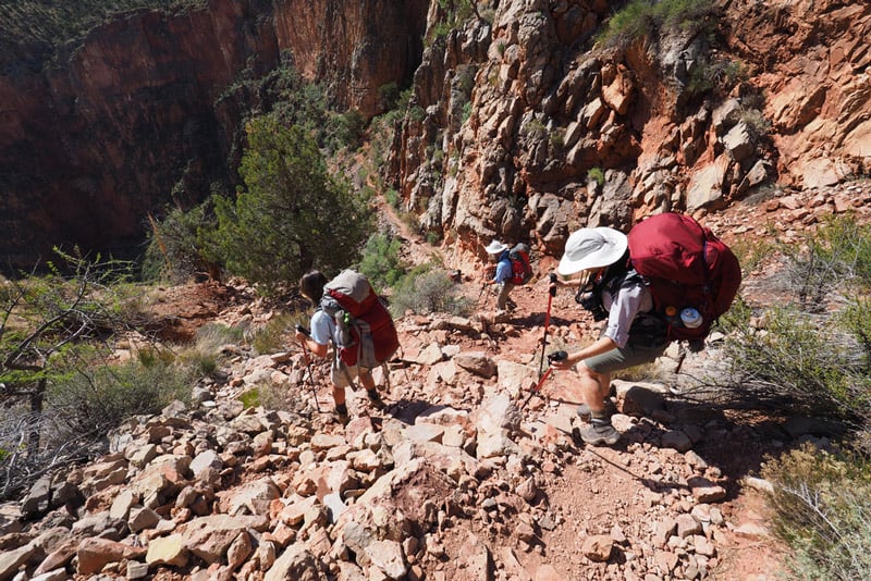 backpackers heading down a steep trail in Grand Canyon National Park Arizona