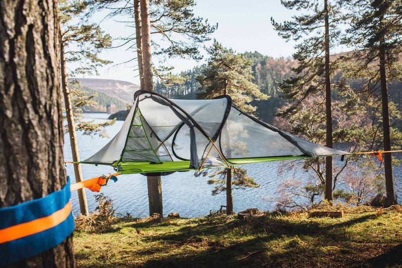 camping tent hanging between three trees
