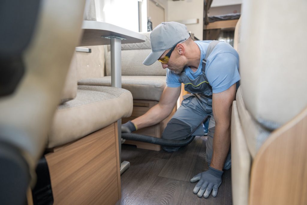 man installing rv furniture in a camper