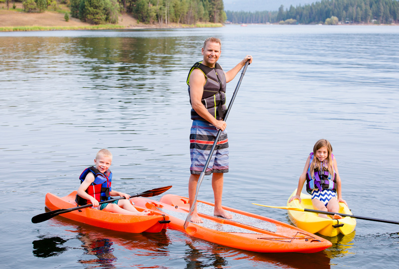 kids swimming and kayaking in a lake