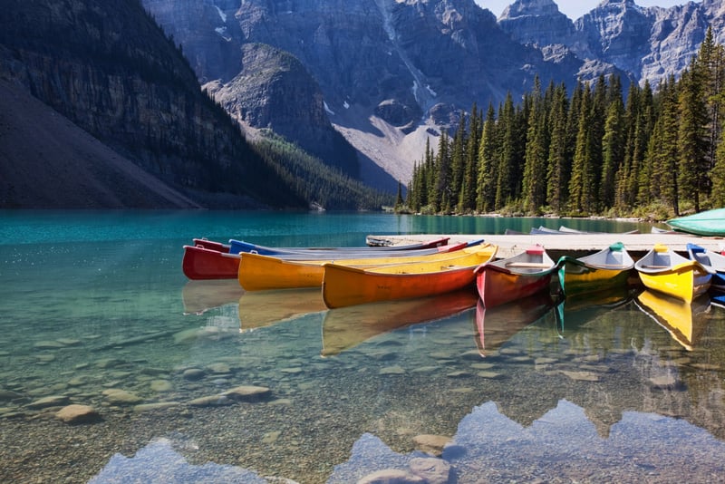 canoe vs kayaks sitting on a lake