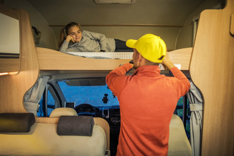 girl laying on rv bedding in a camper