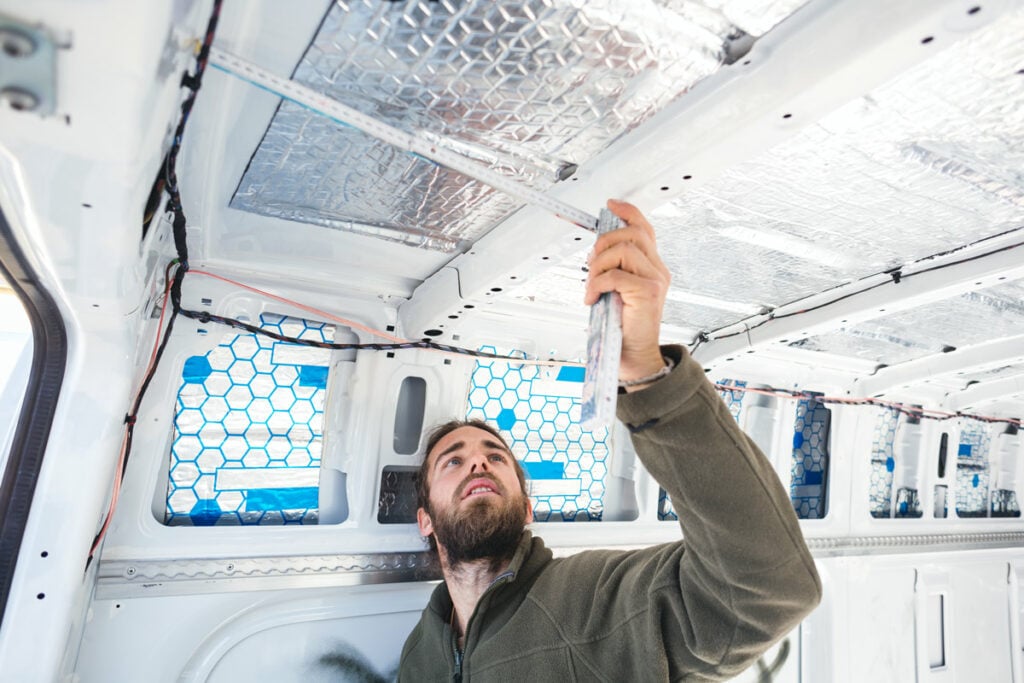 man measuring the interior of a camper van conversion