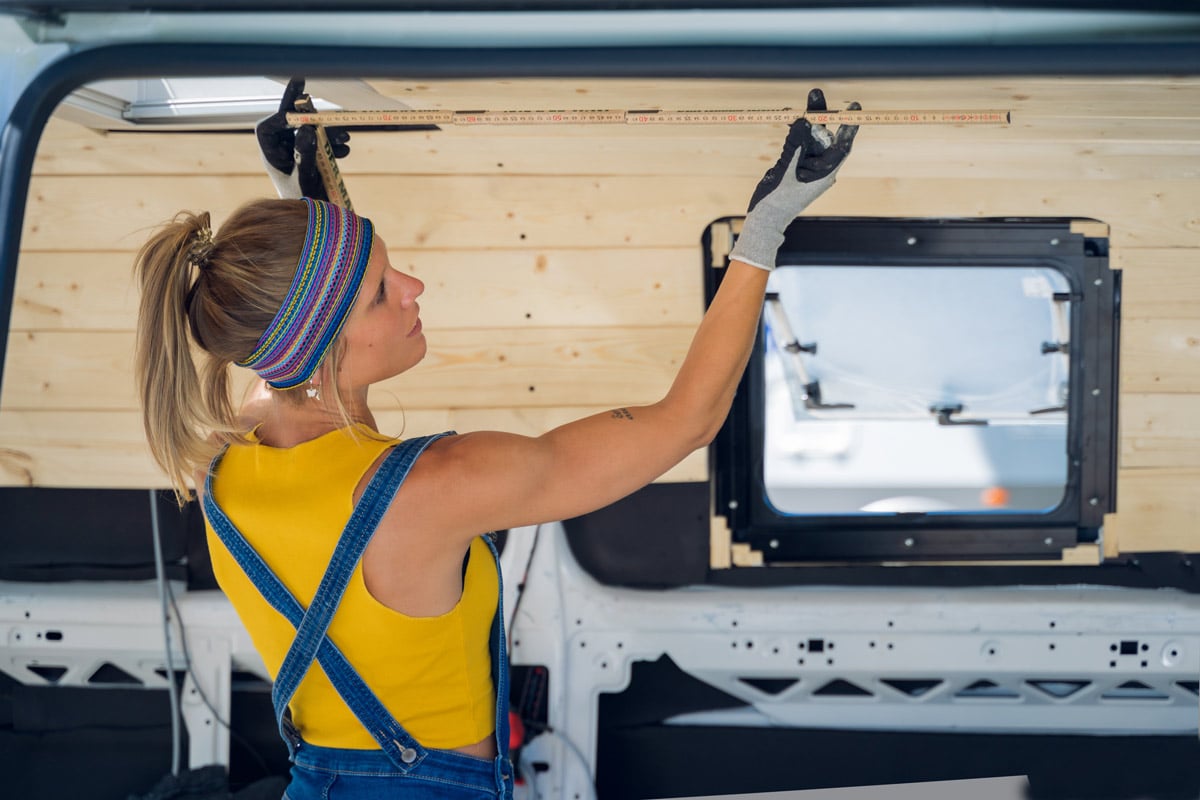 van lifer measuring the interior dimensions of a cargo van to convert it into a camper