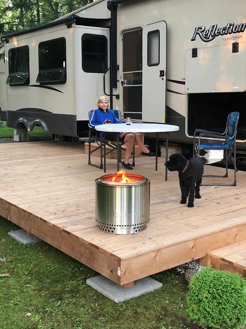 sitting outside of an rv motorhome with a portable campfire pit