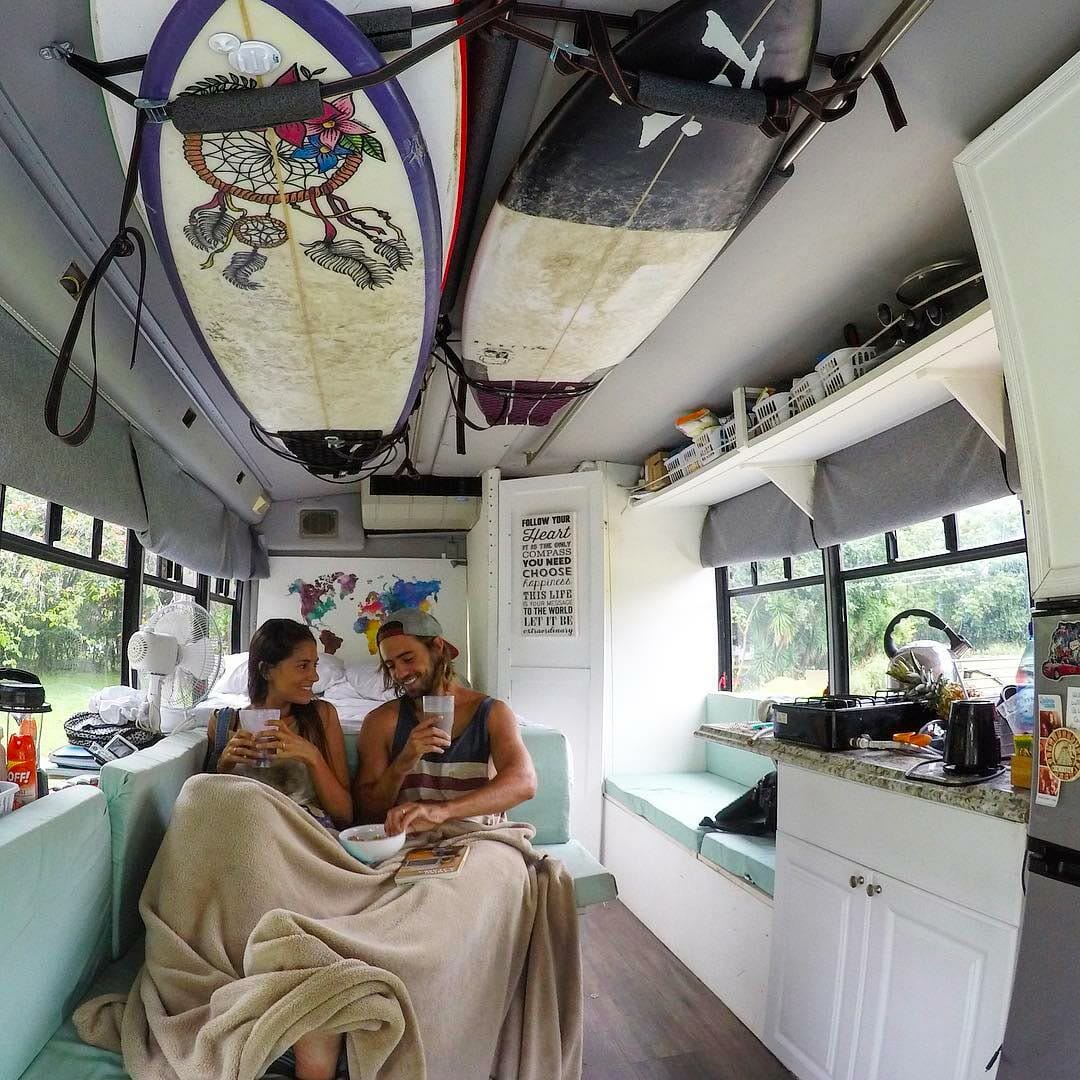 Surfing couple in a school bus conversion