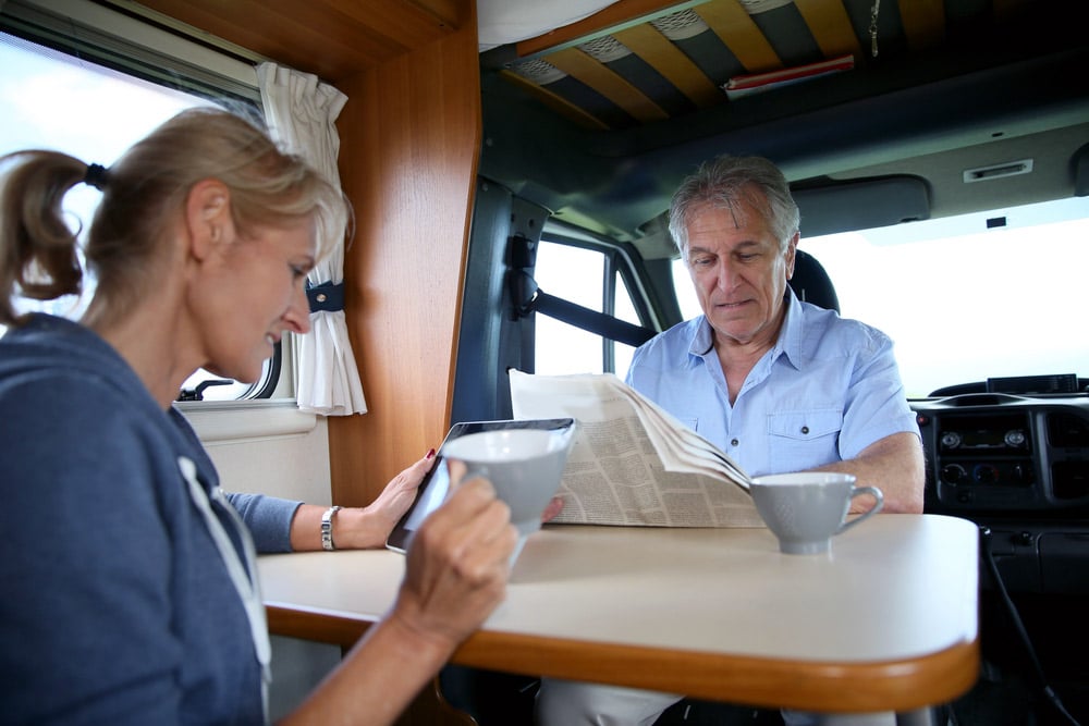 older travel couple drinking coffee brewed from an rv coffee maker