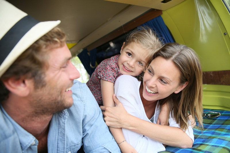 family laying on rv bedsheets