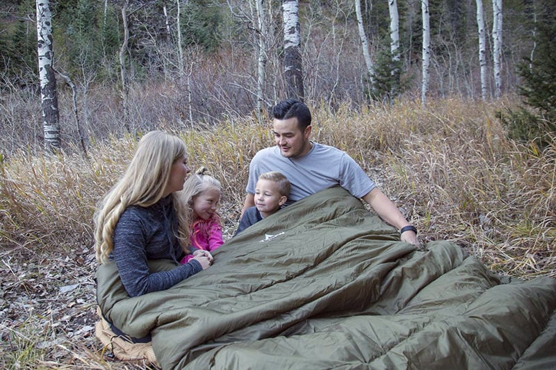 family sleeping together at a campground in a double wide sleeping bag