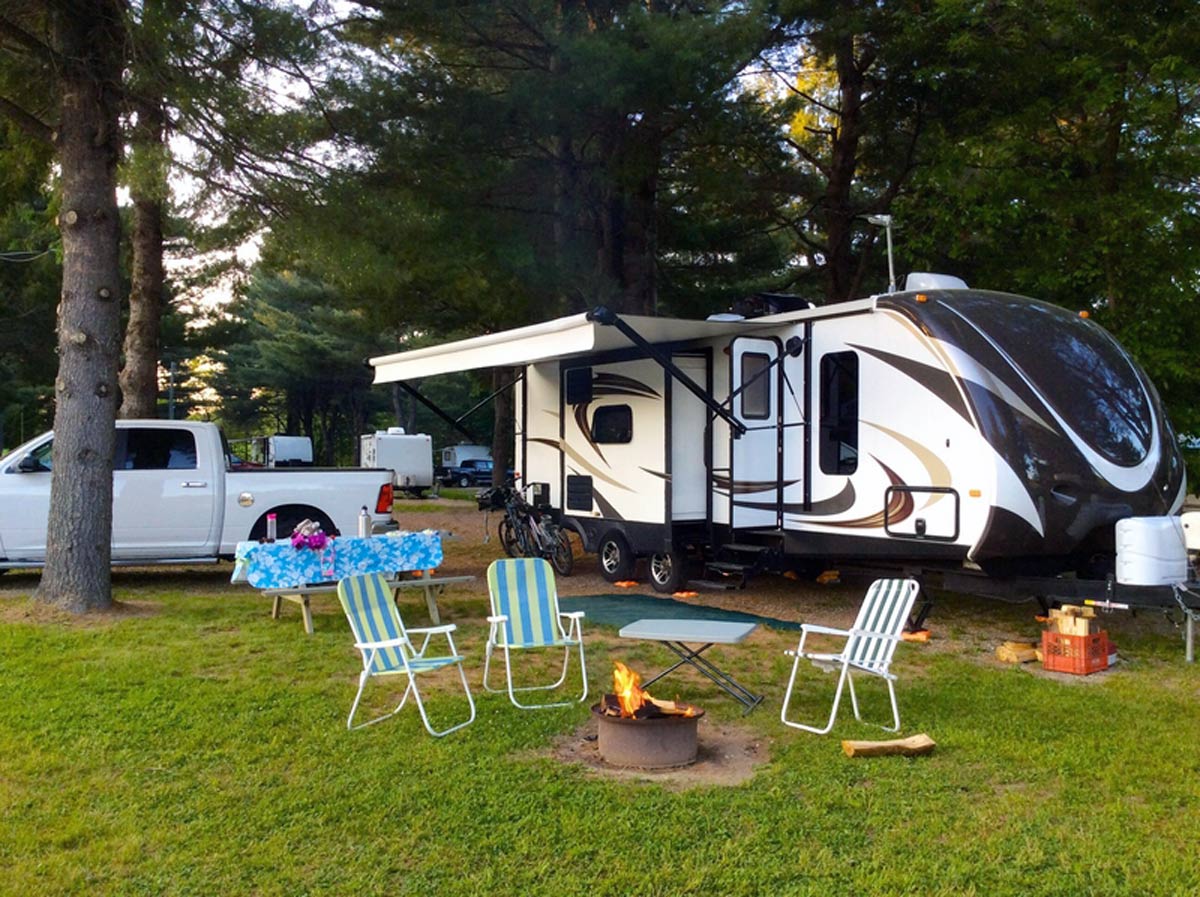 travel trailer parked at a campground in the woods