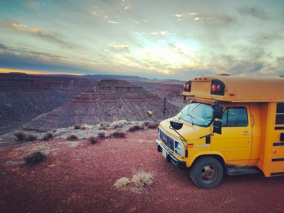 short size school bus conversion parked at a campsite