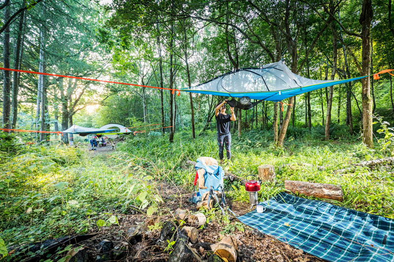 Camping with a hanging tree tent in the woods using a multi-point system