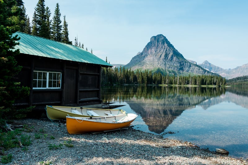 boats resting along the shoreline of two medicine lake in glacier national park