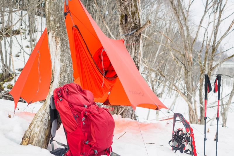winter hammock camping sleeping pad and backpack in the snow