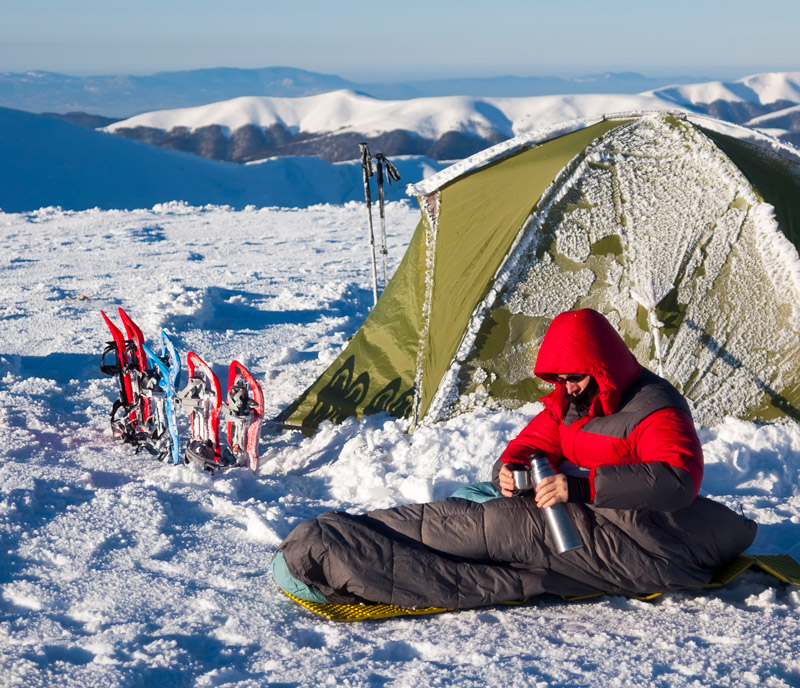 Pouring hot water while winter camping to stay warm