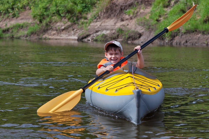 young child kayaking in a lake